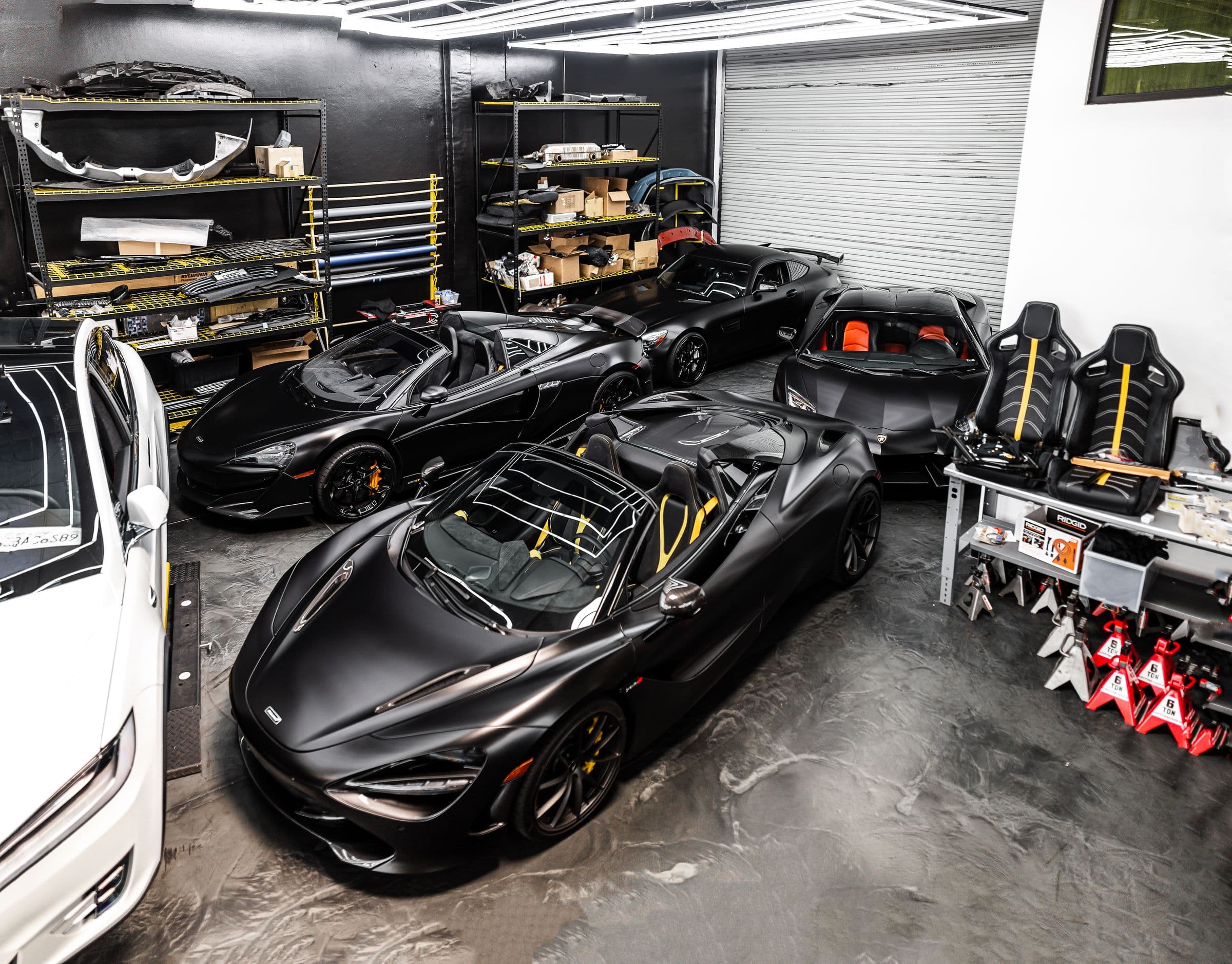 Covered cars raised on lifts inside a storage workshop